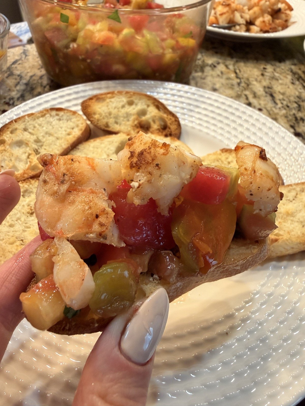 Seared shrimp and diced tomato relish piled on a toasted baguette slice